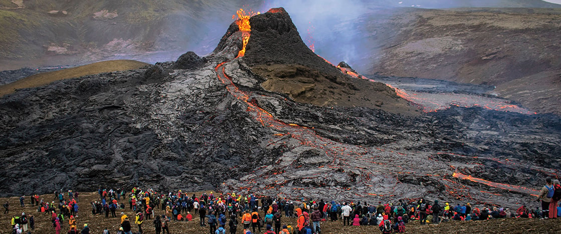 Image of active volcano with crowd of people gathered below