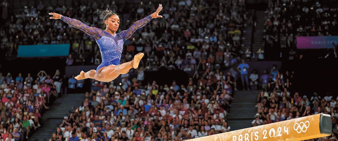 Image of Simone Biles performing on the balance beam at Paris 2024 Olympics