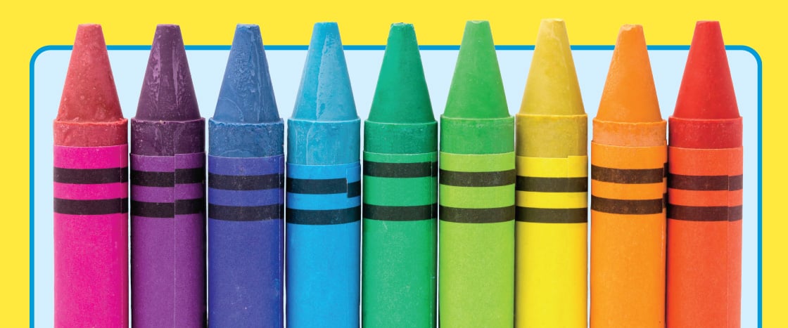 A row of crayons in rainbow colors stand upright side by side